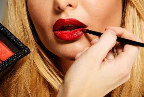 Mua artist painting red lips with tassel