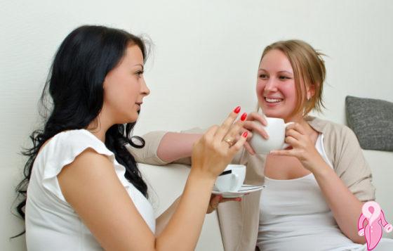 Two women friends chatting over coffee at home