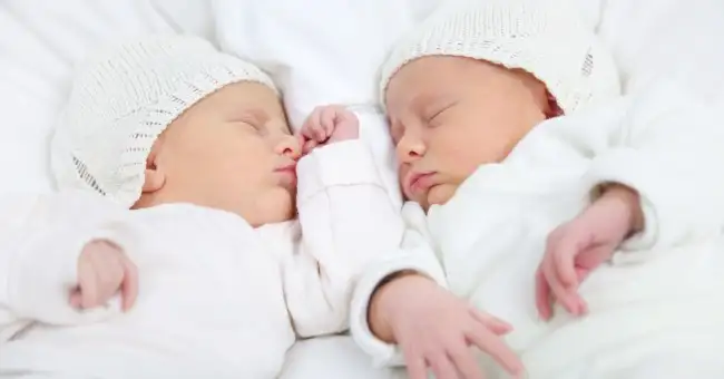 twins_babies_sleeping_bed_newborn_0.webp