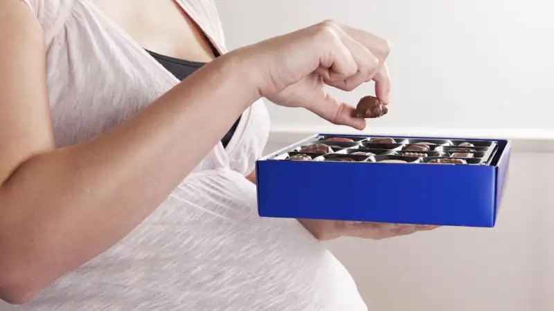woman-eating-chocolates-while-pregnant.webp