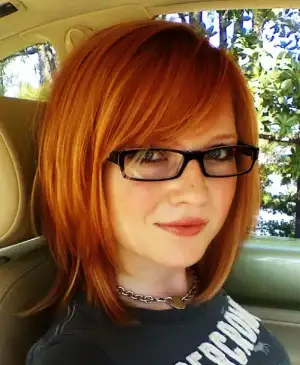 $sexy-redhead-in-car-with-glasses.webp
