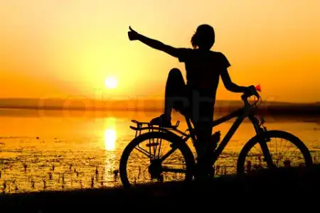 $1497129-887437-silhouette-girl-with-bicycle-nera-the-sea-showing-thumbs-up.webp