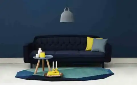 minimalist-blue-interior-design-ideas-navy-blue-wall-dark-blue-sofa-yellow-grey-cushions-915x...webp